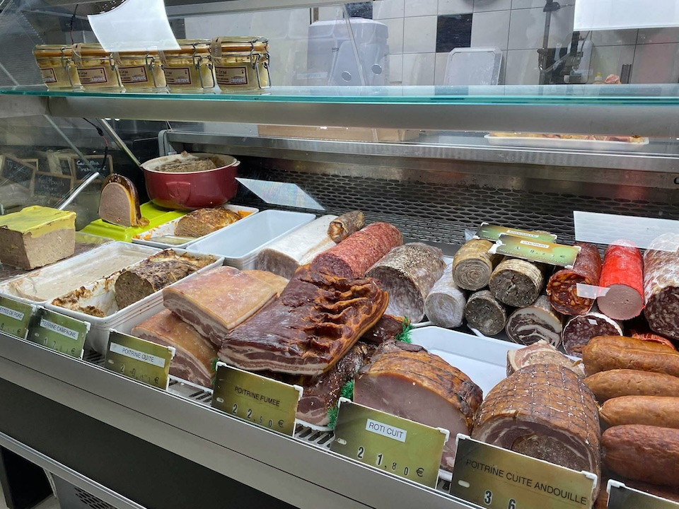 Les charcuteries présentent dans l'étalage de la boucherie d'Au Marché de l'Oust
