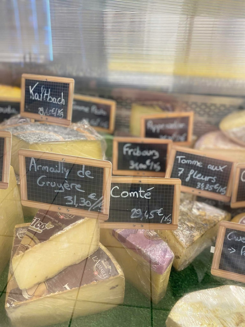 Gros plan sur des fromages  (gruyère, comté, fribourg, tomme aux 7 fleurs, etc.) proposés par Au Marché de l'Oust