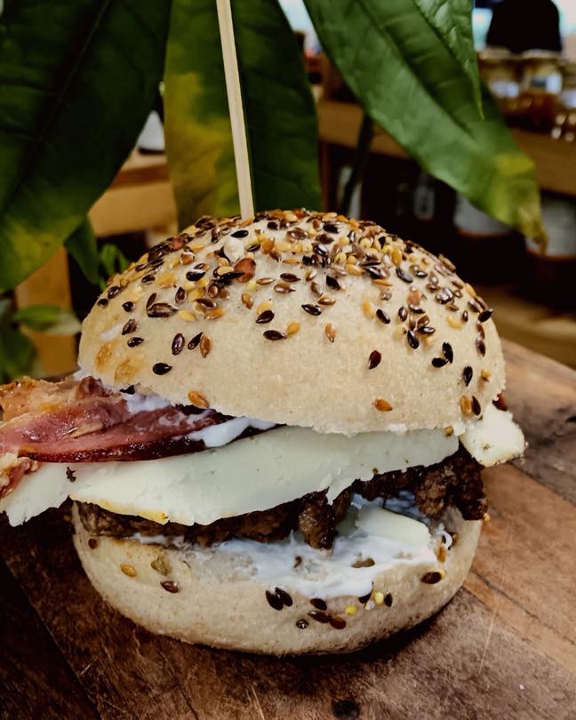 Burger avec steak, tranche de fromage, bacon et sauce blanche en gros plan du Marché de l'Oust