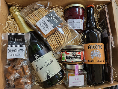 Vue du dessus d'un panier produits remplis de bouteilles et produits secs de l'épicerie Au Marché de l'Oust